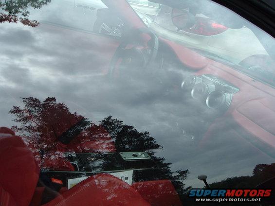 Red car interior with reflection of trees and sky