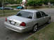 2004 Mercury Marauder - A silver 2004 Mercury Marauder is parked curbside on a street with houses and trees in the background.