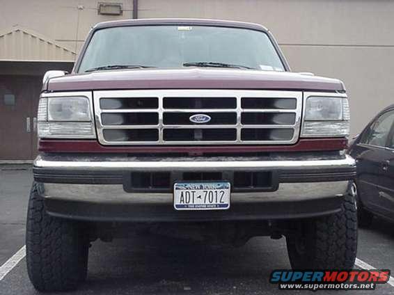 Front view of a maroon Ford F-150 pickup truck with a chrome grille and bumper. License plate reads ADT-7012