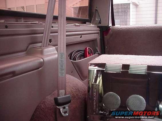 1996 Ford Bronco interior showing brown upholstery, seatbelt, and storage pocket with cables