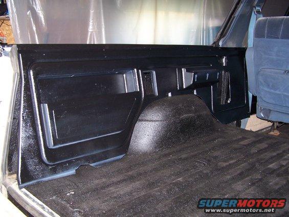 Interior cargo area with black textured lining and blue seats visible