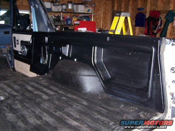 Interior of a vehicle showing the rear cargo area and side panel