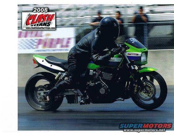 Green and purple motorcycle in motion, rider in black gear. "2008 The Clash of Titans" logo