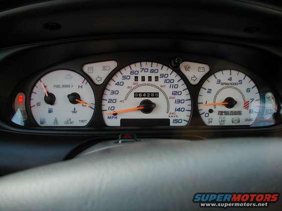 Car dashboard with fuel, temperature, speedometer, and tachometer gauges. Odometer reads 064285