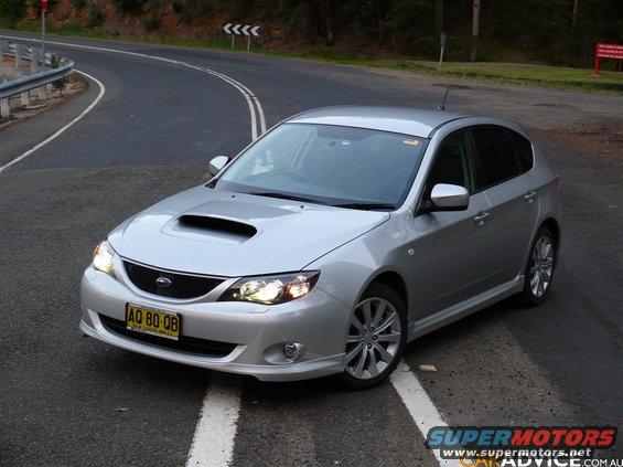 Silver Subaru Impreza hatchback with hood scoop on a winding road. License plate AQ-80-QB