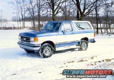1990 Ford Bronco in snow, two-tone blue and white