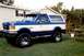 1990 Ford Bronco - This two-tone blue and white Ford Bronco features a light bar on its roof and appears to be a 1990 model.
