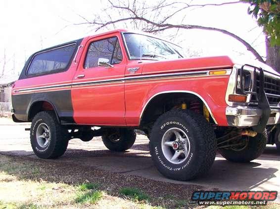 Red and black 1978 Ford Bronco with aftermarket grille guard and off-road tires