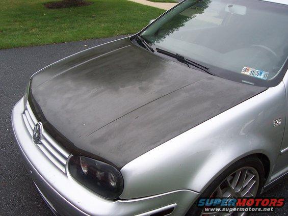 Silver car with a dark hood and tinted headlights