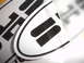 1990 Ford Taurus - Close-up of a white oval emblem with black stripes, possibly a vehicle badge.