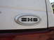 1990 Ford Taurus - Close-up of a white vehicle's rear section, showing an oval emblem with the letters 'SHO'.