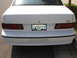 1990 Ford Taurus - The rear of a white Ford Taurus features 'TAURUS' badging and a prominent 'SHO' emblem.
