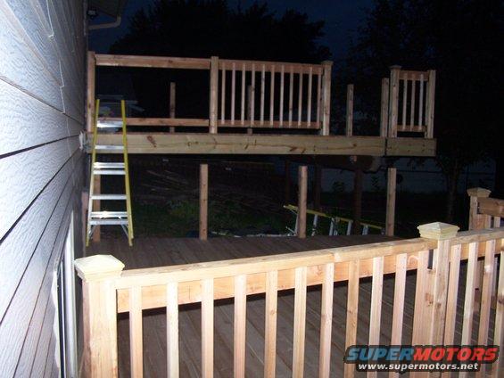 Deck construction with a ladder leaning against the house