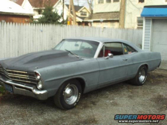 Gray 1967 Ford Galaxie with a prominent hood scoop, seen from the front three-quarter view