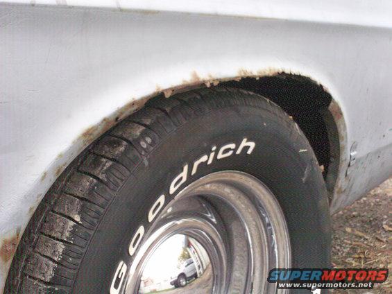 Close-up of rusty rear wheel well and tire with 'Goodrich' text