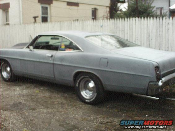 Gray 1967 Ford Galaxie coupe, rear three-quarter view, primer finish, chrome wheels