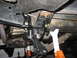 1991 Ford Bronco - Close-up view of aftermarket suspension components and supporting jack stands underneath a vehicle.