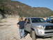 2007 Toyota FJ Cruiser - A man stands by his silver Toyota Tacoma truck in a dry, rocky canyon with mountains in the background.