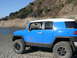 2007 Toyota FJ Cruiser - Blue 2007 Toyota FJ Cruiser parked on a dirt shore with a rocky hillside in the background.