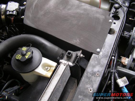 Close-up of engine bay components with hoses and electrical connectors