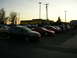 2007 Mazda 3 - A group of cars are parked in a lot during a meet, with a dark gray Mazda 3 in the foreground.