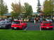 2007 Mazda 3 - Cars gathered in a parking lot with people milling around.