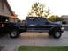 2001 Ford F-350 - A dark blue 2001 Ford F-350 pickup truck is parked in a driveway with a house in the background.