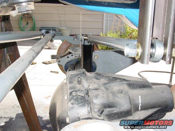 Close-up of a vehicle's front suspension with gray metal arms and a black differential housing