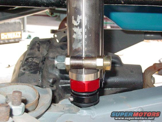 Close-up of a red and black shock absorber mount with metal tubing and bolts