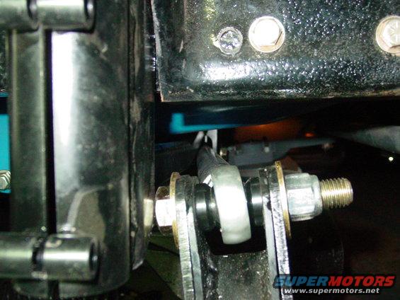 Close-up of a vehicle's suspension linkage with bolts and bushings