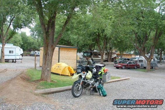 Motorcycle parked at campsite with tents and RVs