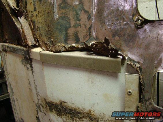 close-up of heavily rusted and damaged metal body panel on a vehicle