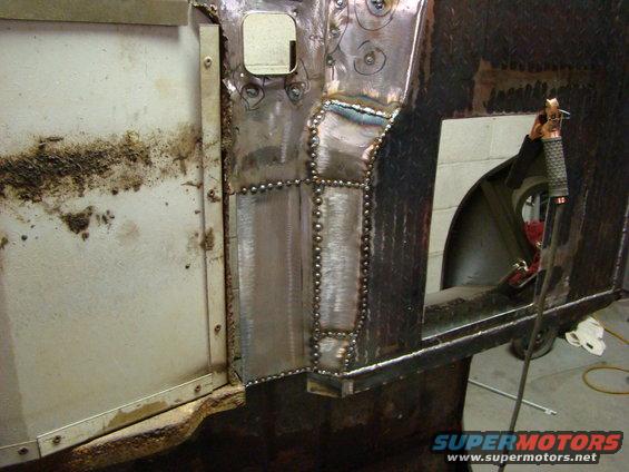 Close-up of metal body panel repair with visible welds and rivets; Supermotors.net logo in lower right