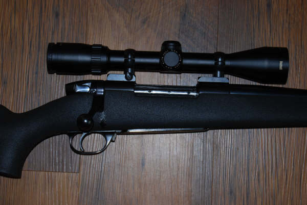 Rifle with scope on wooden background