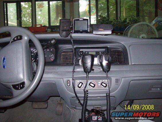 2003 Ford Crown Victoria interior showing dashboard, steering wheel, two microphones, and GPS unit