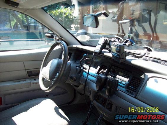 Interior of a police car, showing the steering wheel, dashboard with radio equipment, and a date stamp of 16/09/2008
