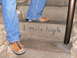 2006 Ford E350 - Stone steps are marked with '1 mile high' and show the lower legs and feet of two individuals wearing jeans and casual shoes.