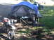 2006 Ford E350 - A dirt bike and campsite setup with a tent and pickup truck, suggesting an outdoor adventure or camping trip.