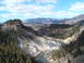 2006 Ford E350 - A wide river flows through a forested canyon, with distant snow-covered mountains under a partly cloudy sky.