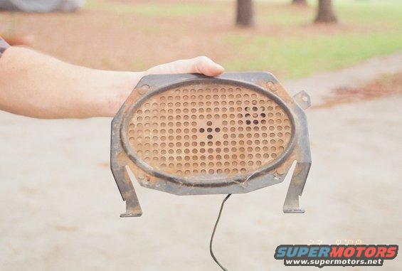 Rusty oval dash speaker with metal mounting brackets and wire