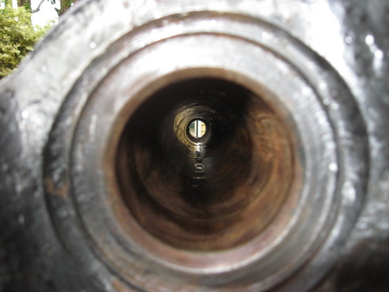 Looking through a metal pipe, seeing a distant opening with light