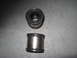 1991 Ford Bronco - Two metal and rubber bushings are shown on a gray concrete surface.