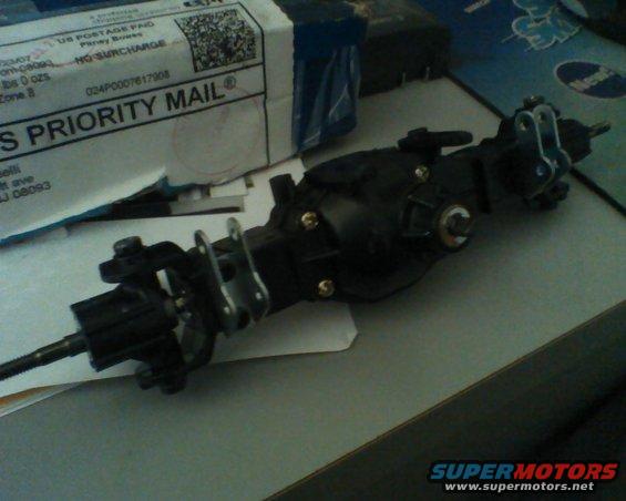 Black automotive part with metal brackets and a threaded shaft