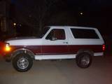 1993 Ford Bronco two-tone white and maroon, side view at night