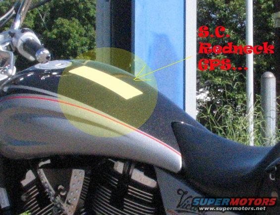 Motorcycle fuel tank with yellow tape and text overlay saying S.C. Redneck GPS