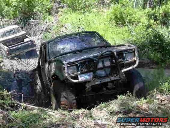 Truck stuck in mud with another truck behind it