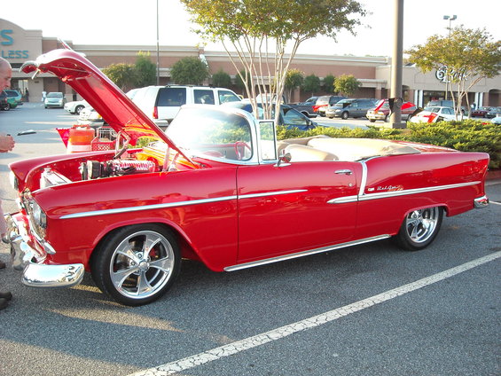Red convertible with hood open, showing engine. Chrome wheels and trim
