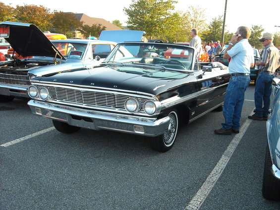 Black 1964 Ford convertible with chrome grille and dual headlights