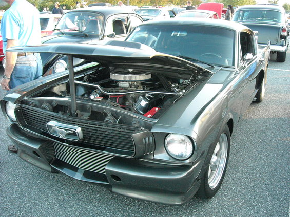Gray 1965 Ford Mustang with hood open, showing engine and chrome air cleaner