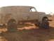 1992 Ford Bronco - Modified panel van sits high on large tires in a dirt lot.